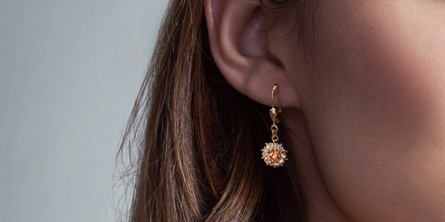 Goldene Ohrhänger mit Zirkonia am Ohr getragen