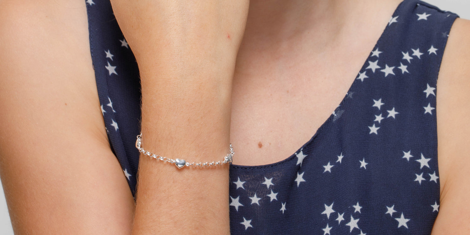 Silbernes Kinderarmband mit Herzdetail an Kinderarm, zarter Kinderschmuck